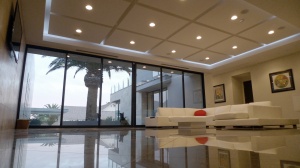 white-l-shaped-sofa-orange-pillow-glass-wall-modern-living-room-open-plan-design